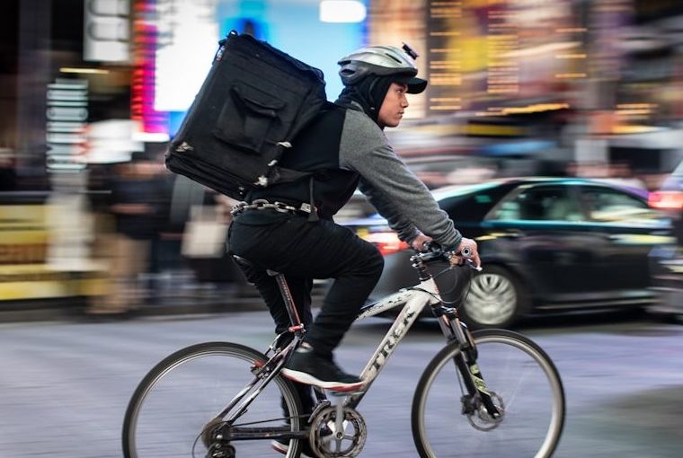 man riding bicycle near vehicles